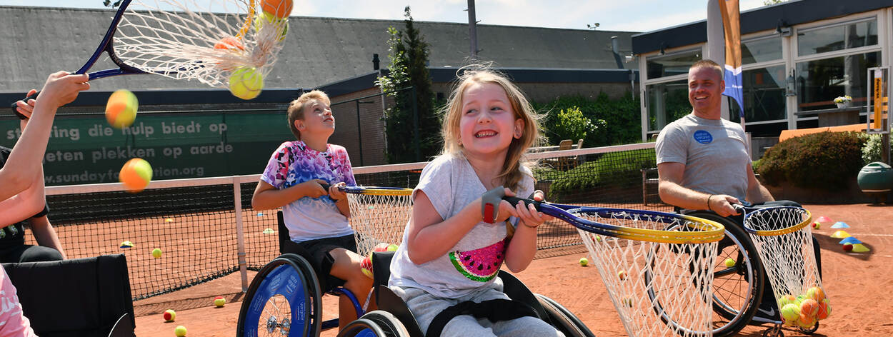 Kinderen in rolstoel hebben plezier tijdens tennisles