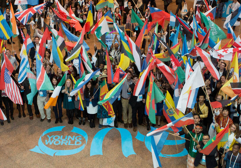 One Young World- groep mensen met gekleurde vlaggen