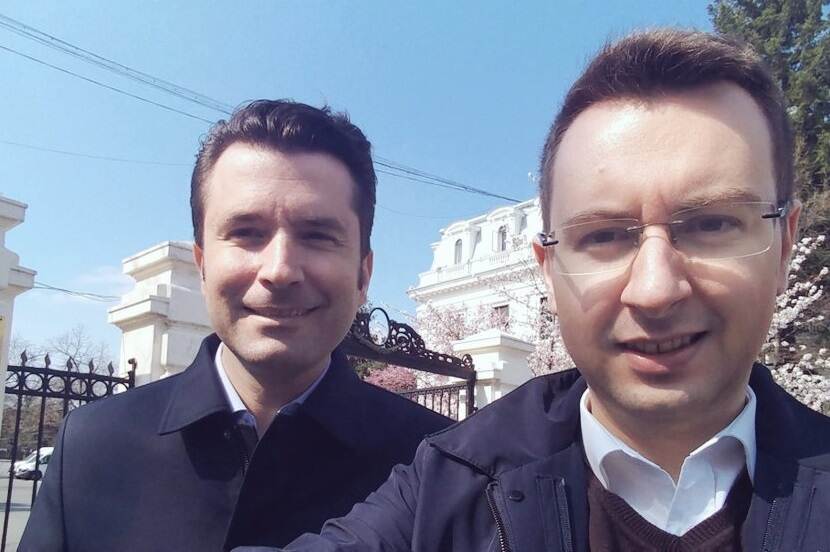 Selfie van 2 mannen met historisch gebouw op achtergrond