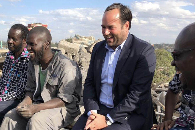Tijmen lacht terwijl hij in gesprek is met drie andere mannen tijdens zijn bezoek in Afrika.