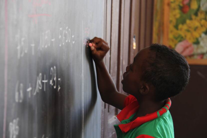Afrikaans jongetje schrijft op bord