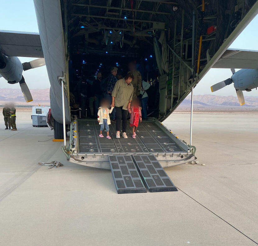 Irma van Dueren begeleidt kinderen van het ambassadepersoneel uit het vliegtuig.