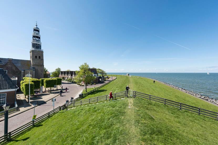 Zicht op Hindeloopen met Grote Kerk, de dijk en het IJsselmeer