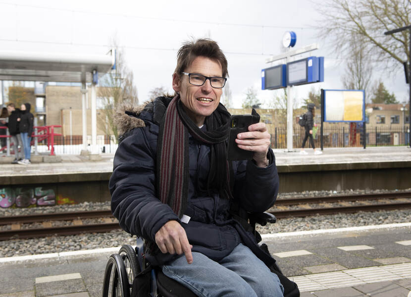 Man in een rolstoel op een treinstation