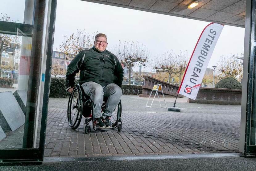 Man in een rolstoel voor een stembureau