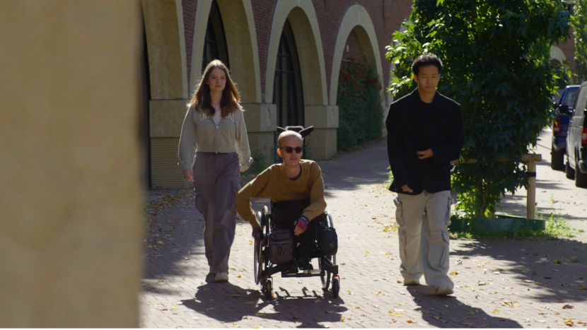 Een persoon in een rolstoel op straat met andere mensen