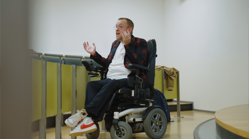Man in een rolstoel in een collegezaal