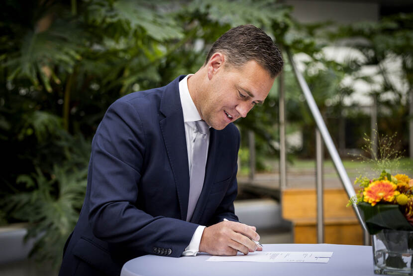 Minister Heinen met koffer.